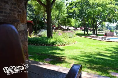 a park with trees and a bench in the grass at Lakeside 1 in Dullstroom