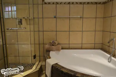 a bath tub in a bathroom with a shower at Lakeside 1 in Dullstroom