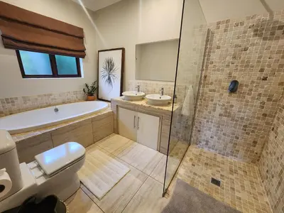 a bathroom with a tub and a toilet and a sink at Maclarty House - Golf Estate Villa in White River