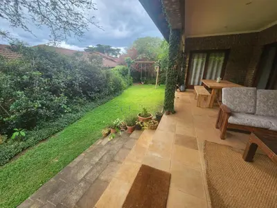 a patio with a couch and a table and a lawn at Maclarty House - Golf Estate Villa in White River