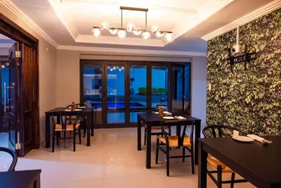 a dining room with black tables and chairs at The Luthe in Thohoyandou