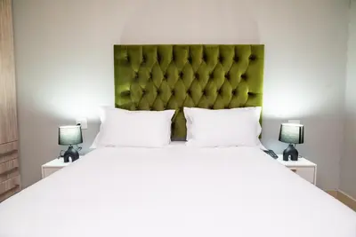 a bedroom with a large bed with two lamps at The Luthe in Thohoyandou