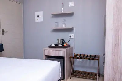 a bedroom with a bed and a table with a tea kettle at The Luthe in Thohoyandou