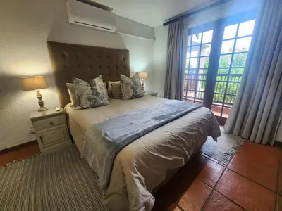 a bedroom with a large bed and a window at Golf Estate Vacation Property - Poseidon's Knoll in White River