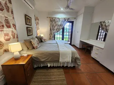 a bedroom with a bed and a desk and a window at Golf Estate Vacation Property - Poseidon's Knoll in White River