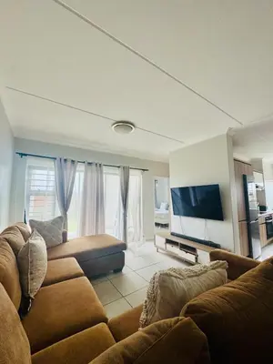 a living room with a couch and a flat screen tv at 126Theblyde in Pretoria