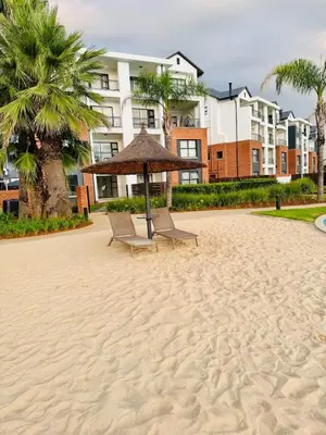 two chairs and an umbrella on a beach at 126Theblyde in Pretoria