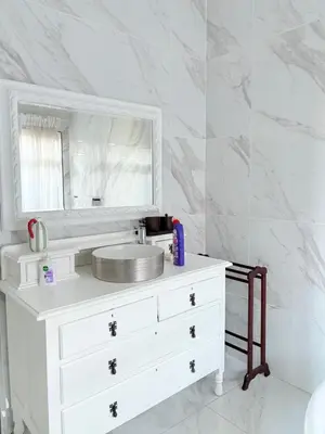 a white bathroom with a sink and a mirror at View at 81 in Hartbeespoort