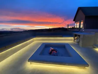 a hot tub on the roof of a house with a sunset at Gweda Lodge in Ouklip