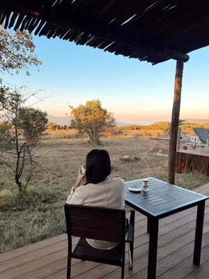 a woman sitting at a table talking on a cell phone at Gweda Lodge in Ouklip