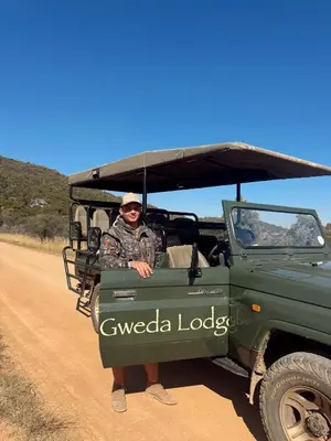 a man standing in the back of a green jeep at Gweda Lodge in Ouklip