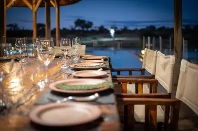 a long table with plates and wine glasses on it at Xidulu Safari Lodge - Makalali in Makalali Game Reserve