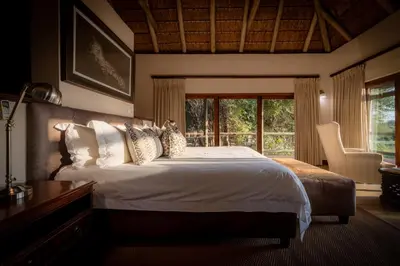 a bedroom with a large bed and a window at Xidulu Safari Lodge - Makalali in Makalali Game Reserve