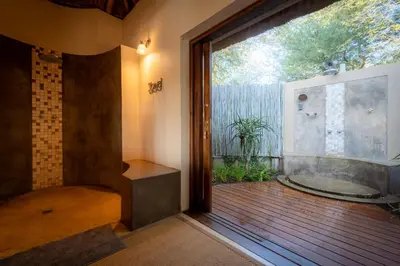 a bathroom with a tub and a large window at Xidulu Safari Lodge - Makalali in Makalali Game Reserve