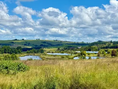 a view of a field with two water reservoirs at Stone Creek Mountain Lodge in Dullstroom