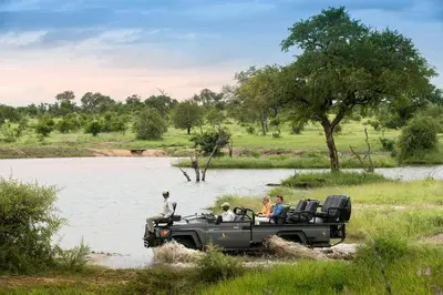 a group of people in a jeep crossing a river at Cheetah Plains Private Game Reserve in Sabi Sand Game Reserve