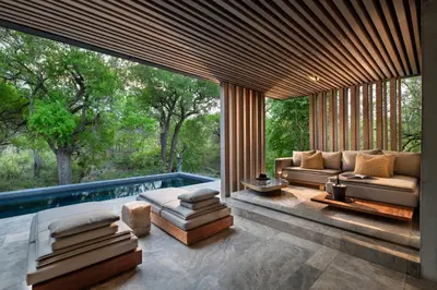 a living room with a couch and a swimming pool at Cheetah Plains Private Game Reserve in Sabi Sand Game Reserve