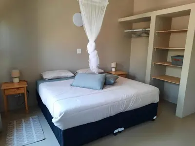 a bedroom with a bed with a white bedvisor at Selfcatering accommodatie Villa BoerenBerg Marloth park, zuid Afrika in Marloth Park