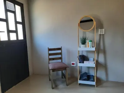 a room with a chair and a mirror and a shelf at Selfcatering accommodatie Villa BoerenBerg Marloth park, zuid Afrika in Marloth Park