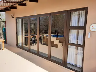 a room with sliding glass doors with a patio at Selfcatering accommodatie Villa BoerenBerg Marloth park, zuid Afrika in Marloth Park