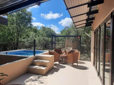 a patio with chairs and a swimming pool at Selfcatering accommodatie Villa BoerenBerg Marloth park, zuid Afrika in Marloth Park