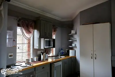 a kitchen with a white refrigerator and a sink at Cherry Grove 3 in Dullstroom