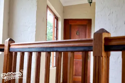 a wooden staircase with a wooden door in a room at Cherry Grove 3 in Dullstroom