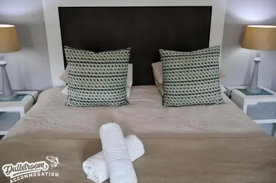 a bed with two towels on it with two lamps at Cherry Grove 3 in Dullstroom