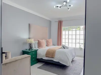a bedroom with a bed with a green dresser and a window at Amoris Guesthouse - Hillcrest Brooklyn in Pretoria