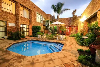 a swimming pool in the backyard of a house at Dormio Manor Guest Lodge in Secunda