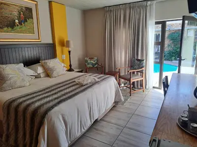 a hotel room with a bed and a pool at Dormio Manor Guest Lodge in Secunda
