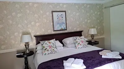a bedroom with a bed with two towels on it at Dormio Manor Guest Lodge in Secunda