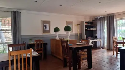a dining room with a table and chairs at Dormio Manor Guest Lodge in Secunda
