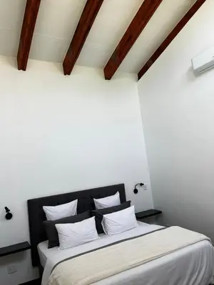 a bedroom with a large bed with white pillows at The Cottage in Secured Estate in Pretoria