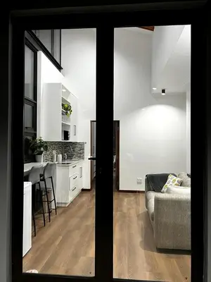 a living room with a couch and a kitchen at The Cottage in Secured Estate in Pretoria