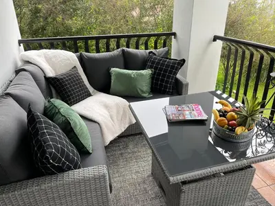 a patio with a couch and a table on a balcony at Labacht Home with The view in Dullstroom