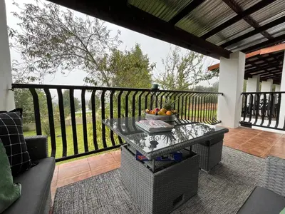 a table with a bowl of fruit on a balcony at Labacht Home with The view in Dullstroom