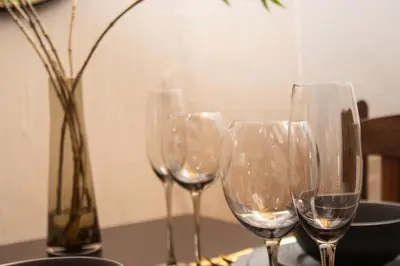 four wine glasses sitting on a table with a vase at Amani Peaceful Home in Centurion