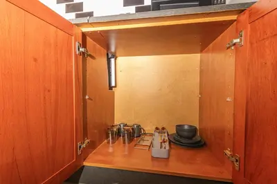 a kitchen with a wooden cabinet with pots and pans at Amani Peaceful Home in Centurion