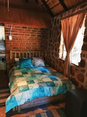 a bedroom with a bed in a brick wall at Thaba Tshwene Game Farm in Modimolle