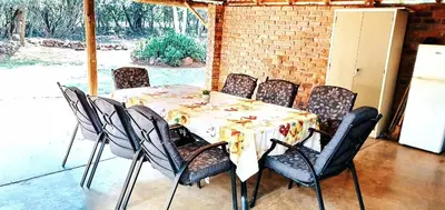a table with chairs and a table and a table and a table and chairsktop at Thaba Tshwene Game Farm in Modimolle