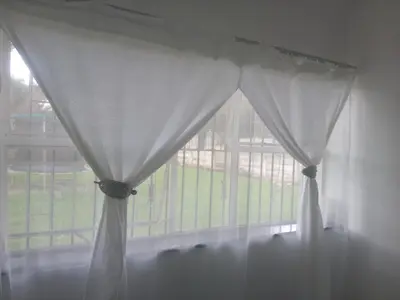 a window with a white curtain in a room at Inspire living home in Kempton Park