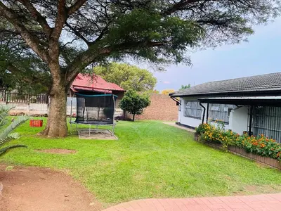 a yard with a tree and a swing at Inspire living home in Kempton Park