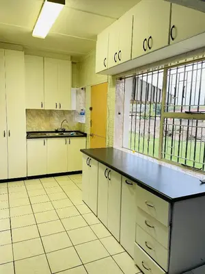 a kitchen with white cabinets and a black counter top at Inspire living home in Kempton Park