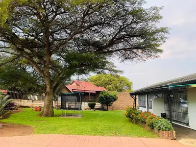 a tree in a yard next to a house at Inspire living home in Kempton Park