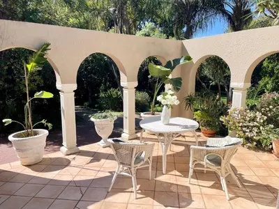 a patio with a table and chairs and plants at Patches Place in Pretoria