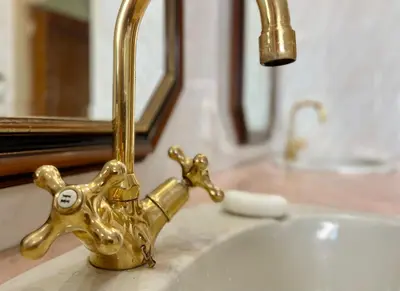 a gold faucet on a sink in a bathroom at Patches Place in Pretoria