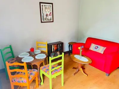 a living room with a red couch and a table and chairs at Patches Place in Pretoria