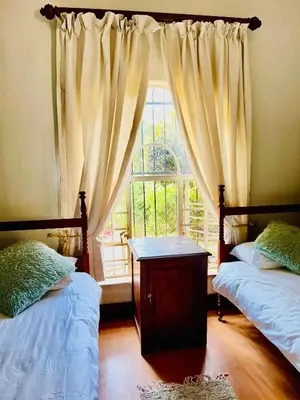 a bedroom with two beds and a window at Patches Place in Pretoria