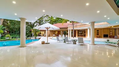 an indoor pool with chairs and an umbrella at Villa Christies at 32 on Russell in Nelspruit